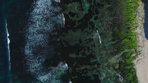 Aerial drone view of waves breaking along a rocky coatline Stock Footage 143514029