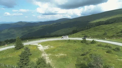 Aerial Drone view of white bus on mountain road agains beautiful mountains Stock Footage 157534748