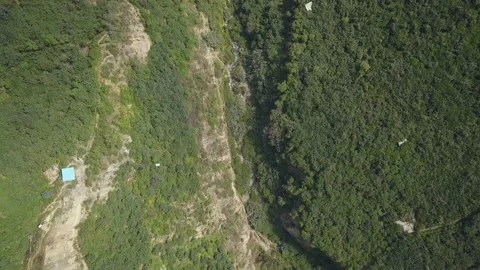 Aerial drone view of a white cable car ride over a lot of vegetation and a river 库存影片 198779034