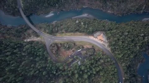 Aerial Drone View of Winding Forest Road and River Landscape Stock Photos