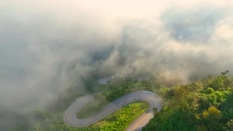Aerial drone view of a winding mountain road through a forest. Stock Footage 320040125