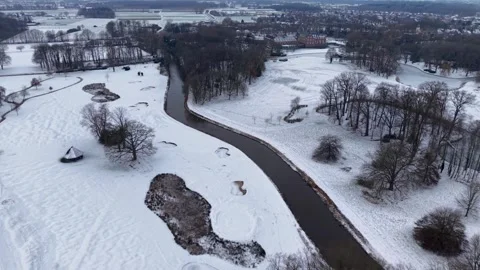 Aerial drone view of a winding river flowing through a snowy winter landscape Stockbeeldmateriaal 330751721