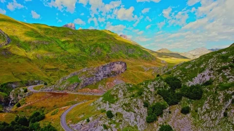 Aerial drone view of winding road in lush green mountain valley Stock Footage 345467198