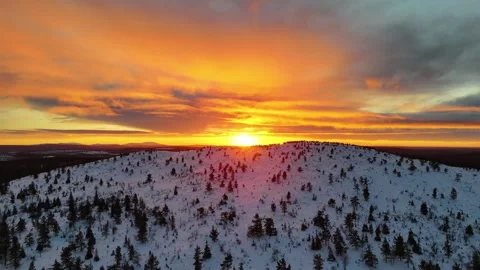 Aerial drone view of a winter sunset behind a snowy mountain top in Lapland Stock Footage 301323519