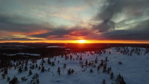 Aerial drone view of winter sunset over snowy forest and mountain top in Lapland Stock Footage 301325448