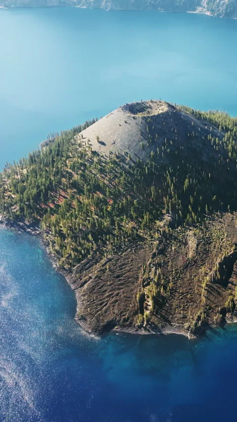 Aerial drone view of Wizard Island volcano cone rising from the deep blue waters Stock Footage 332372207