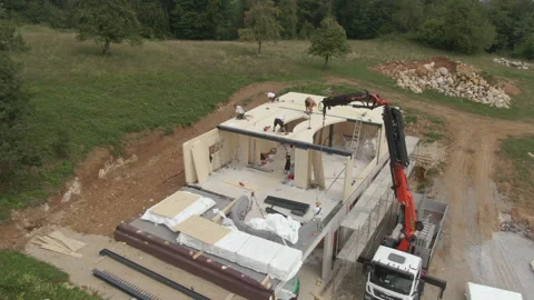 AERIAL: Drone view of workers placing CLT panels on a house in the countryside. Stock Footage 307835066