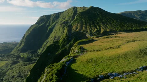 Aerial drone wide view of a dramatic volcanic cliff edge dropping into a lush 库存影片 335708946