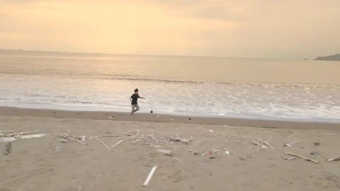 Aerial Drone of Young Man Running Along Beach at Sunset Stock Footage 326325912