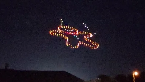 Aerial drones at night form shape of Christmas Gingerbread Man, then nibble legs Видео 257385399
