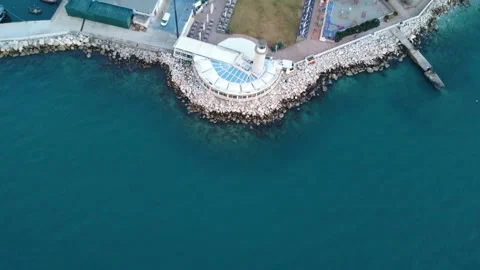 Aerial dynamic view of lighthouse marina and coastal city waterfront Stock Footage 338108505