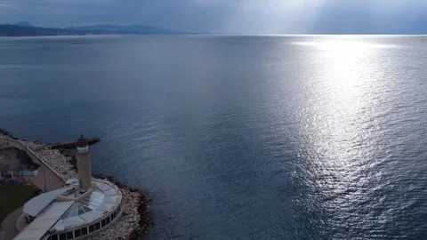 Aerial dynamic view of a traditional lighthouse on a pier by the ocean Stock Footage 338108332
