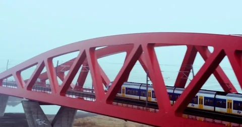 Aerial of electric train running on a bridge over a river on a foggy day Stock Footage 81533095