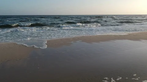 Aerial Elevating View Approaching Waves Over the Beach at Sunset Stock Footage 129251970