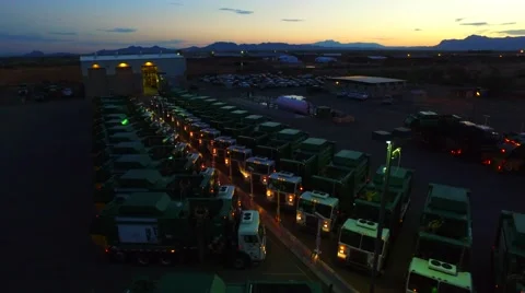 Aerial elevator rotation panning down on waste management trucks Stock Footage