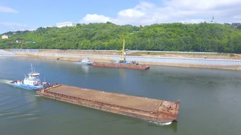 AERIAL: An empty barge is floating along the river. Video stock 87065544