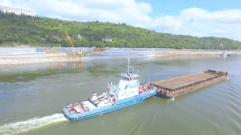 AERIAL: An empty barge floats on the background of embankment. Stock Footage 87065380