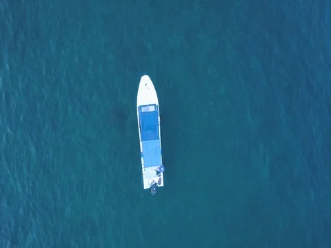Aerial of empty boat moored in the turquoise sea Video stock 83689807