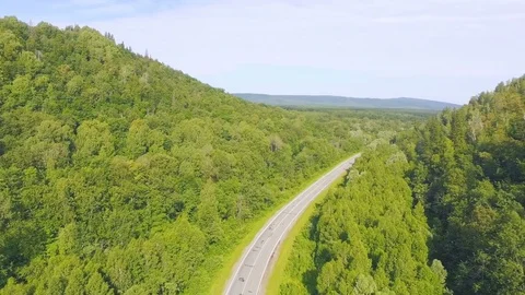 AERIAL: Empty highway around huge mountain among the forest. Video stock 78035039