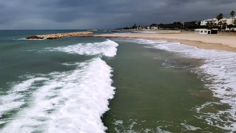 Aerial empty sand beach with rolling waves under dark sky Stock Footage 103299209
