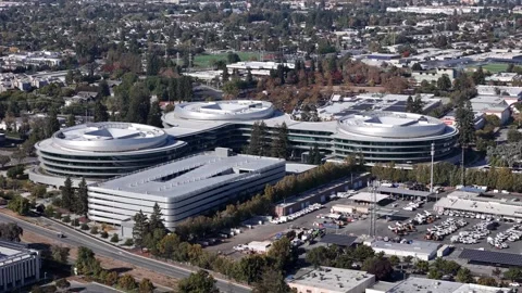 Aerial establishing shot of the Apple Wolfe Campus (AC3), a modern corporate Stock Footage 317761461