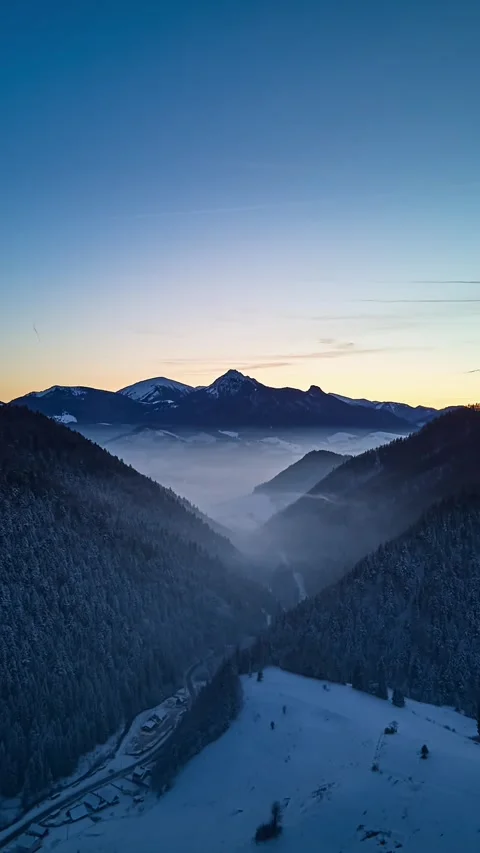 Aerial evening hyperlapse flying forward over snowy forest valley with mist and Stock-Footage 323383930