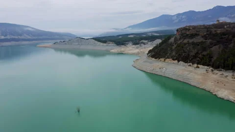 Aerial | Exposed dead tree in turquoise water of lake Embalse de Yesa, Spain Stock Footage 168375864