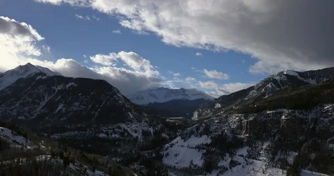 Aerial: fast moving clouds over snowy rocky mountain pass in Telluride, Colorado Video stock 101859364