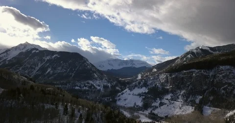 Aerial: fast moving clouds over snowy rocky mountains in Colorado Stock Footage 101860210