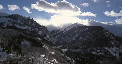 Aerial: fast moving clouds over snowy mountain peaks in Telluride, Colorado Stock Footage 101862851