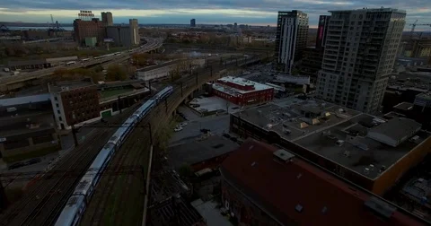 Aerial fight back over train tracks towards a building with "Love me" painted on Stock Footage 77811994
