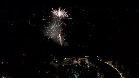 Aerial fireworks exploding at night sky over city lights Video stock 316311582