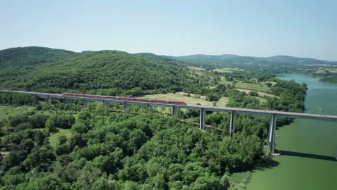 Aerial flight 4K pan view rail bridge Freccia Rossa ETR 1000 Train passes by Stock Footage 196233470