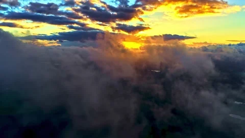 Aerial flight above dramatic clouds at golden sunrise Stock Footage 341328426
