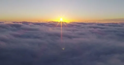 Aerial flight above glowing clouds at sunset Stock Footage 326309890