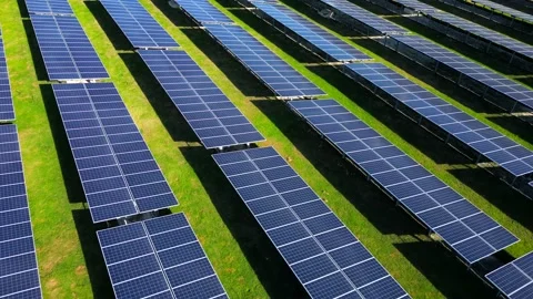 Aerial flight above the rows of solar panels in the green field. Farm producing Vidéo 236149316