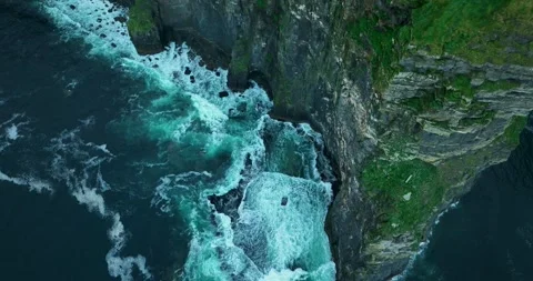 Aerial flight along Cliffs of Moher with waves crashing against sea cliffs Stock Footage 339506185