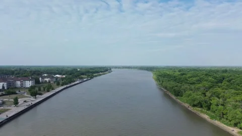 Aerial flight along a river separating a city and a green forest. Stock Footage 312591146