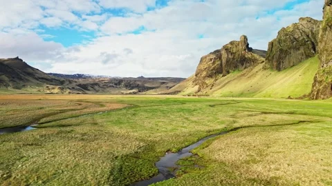 Aerial flight along stream between volcanic mountains Iceland 4K Stock Footage 344113664