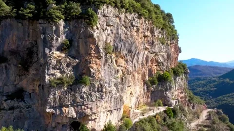 Aerial flight along vertical limestone cliffs above mountain valley Stock-Footage 341327817