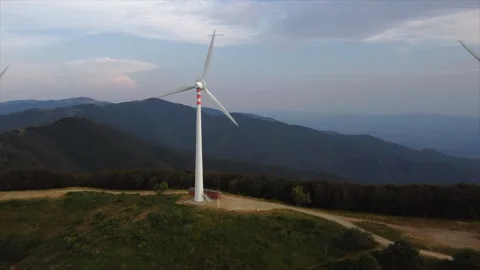 Aerial flight around rotating wind turbine at dusk Stock Footage 322788572