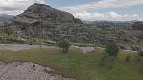 Aerial Flight Backward Over Massive Rock Formation Stock Footage 344664642