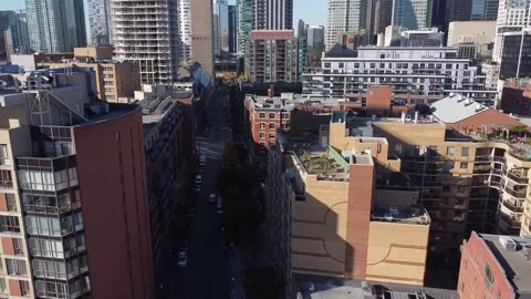 Aerial flight backwards over a road as the camera pans up to reveal the Toronto  Stock Footage 151934096