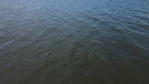 Aerial flight backwards starting with camera looking down at water and panning u Stock Footage 151975496