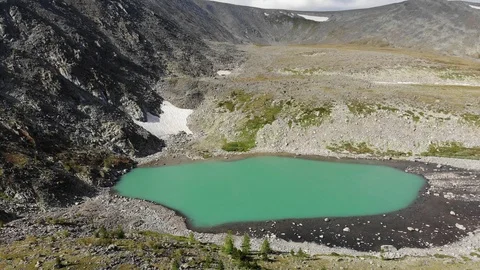 Aerial flight backwards under emerald mountain lake. Altai 動画素材 103372356