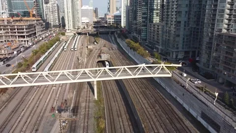 Aerial flight backwards while looking at a passenger train disappear into train  Stock Footage 151935812