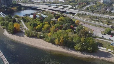 Aerial flight backwards while panning up to reveal Gardiner Expressway Humber Ba Stock Footage 151980280