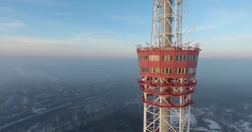 Aerial flight of the copter flying back from the red TV tower at the background Stock Footage 85899710