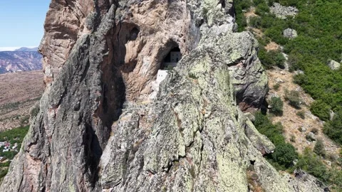 Aerial Flight Crossing Mountain Cliffs Toward Ancient Rock Stock Footage 339502622