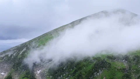 Aerial flight deep inside clouds high above mountain tops. Clouds floating Stock Footage 135321941